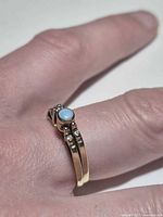Ring worn on hand showing two-band design, turquoise cabochon and diamond accents