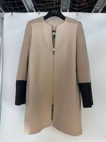 Front view of beige Club Monaco mid-length coat on hanger