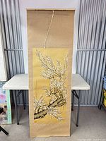 Full view of hanging scroll with plum blossom artwork and silk brocade mounting