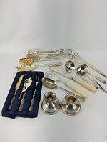 Group shot of entire lot showing flatware, candlesticks and cocktail pick set
