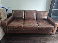 Front view of entire sofa showing three cushions and leather wear