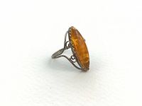 Profile view of sterling silver ring showing openwork shank and marquise amber cabochon