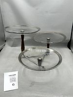 Front view showing all three glass tiers, teak posts and chrome base