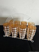 Front view of eight marigold tumblers in white metal carrier