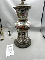 Side view of porcelain vase lamp on wood base with power cord visible