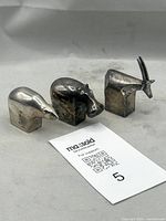 Three silver-plated animal paperweights grouped