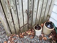 Front view showing both stoneware jugs beside iron tongs