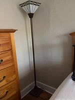 Full view of lamp beside furniture showing height and design