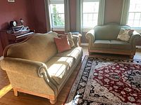 Sofa and loveseat showing upholstery, wood trim, pillows
