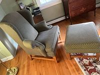 Wingback chair and ottoman angled view showing upholstery pattern and wood bases
