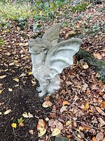 Front right view of gray cast concrete gargoyle statue in outdoor setting