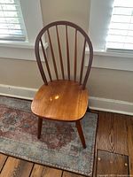 Full view of oak spindle back chair against wall and rug