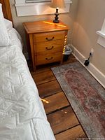 Nightstand beside bed with lamp on top