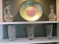 Full lot showing two decanters, decorative charger, three vases