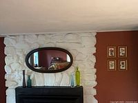 Overall view of mirror, bottles, prints on wall