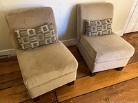 Front view of both beige slipper chairs with geometric pillows