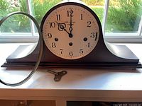 Front view of Seth Thomas tambour mantel clock with bezel open and key shown