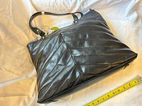 Front view of black Franklin Covey tote with diagonal stitching, measuring tape shows width ~15 inches