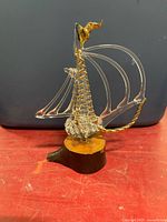 right side view of glass sailboat on wood base