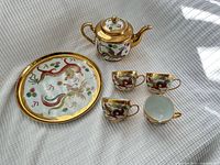 Complete set: teapot, four teacups, tray on fabric backdrop
