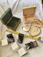 Overview of open trinket boxes, rings in boxes, measuring tape