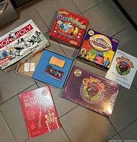 Group shot of all games: Monopoly, Cranium, Consensus Junior Edition, Cashflow, The Human Body jigsaw book
