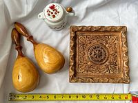 Overall lot showing carved plaque, pair maracas, small teapot, tape for scale