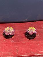 Two iridescent bead lotus figurines on black stands