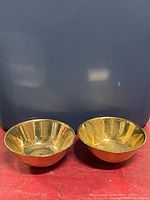 Two gold metallic ceramic bowls side by side