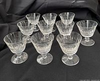 Ten crystal stem cups on black fabric