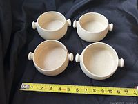 Top view of four ceramic soup bowls with tape measure showing approx 5 in. diameter