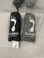 Two packed Eureka El Capitan 4 footprints in stuff sacks, one bagged in plastic