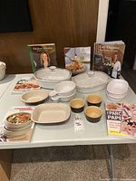 Overall lot with casseroles, stoneware dishes, ramekins, measuring bowls, cookbooks
