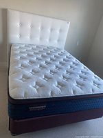 Full view of bed showing mattress, headboard and base