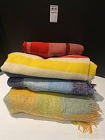 Stack of four blankets showing colours and textures