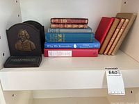 Shelf with bookend, books including Anne Of Green Gables and Why We Remember, red and tan classics