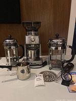 Group shot showing all items: Breville grinder, two Bodum presses, frothing pitcher, scoop, frother, filters, Boveda packet