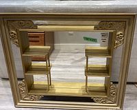 Full view of mirror showing shelves and ornate gold frame
