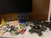 Overall view of lot on table showing plant caddies, fertilizers, tools, gloves and decorative items