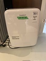 Front view of Garrison dehumidifier showing brand logo and taped dimensions label
