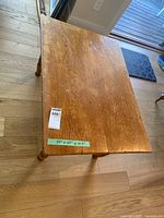 Top view of rectangular wooden coffee table with measurement tape showing 34" x 24"