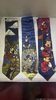 Three Disney ties laid out showing full front designs