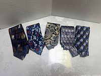 All five ties laid out side by side showing patterns
