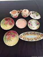 All seven porcelain pieces laid out on black background