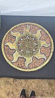 Full view of round Aztec calendar plaque on surface