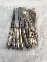 Bagged assortment of silver-plated cutlery showing quantity and handle pattern