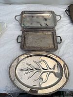 Overview of three silver-plated trays: two rectangular, one oval carving platter
