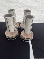 Four stacks of espresso cups and saucers in wire racks