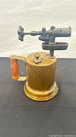 Full view of brass blow torch showing reservoir, handle and burner