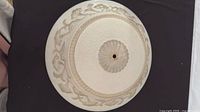 Top view of complete round frosted glass shade showing central hole and floral border